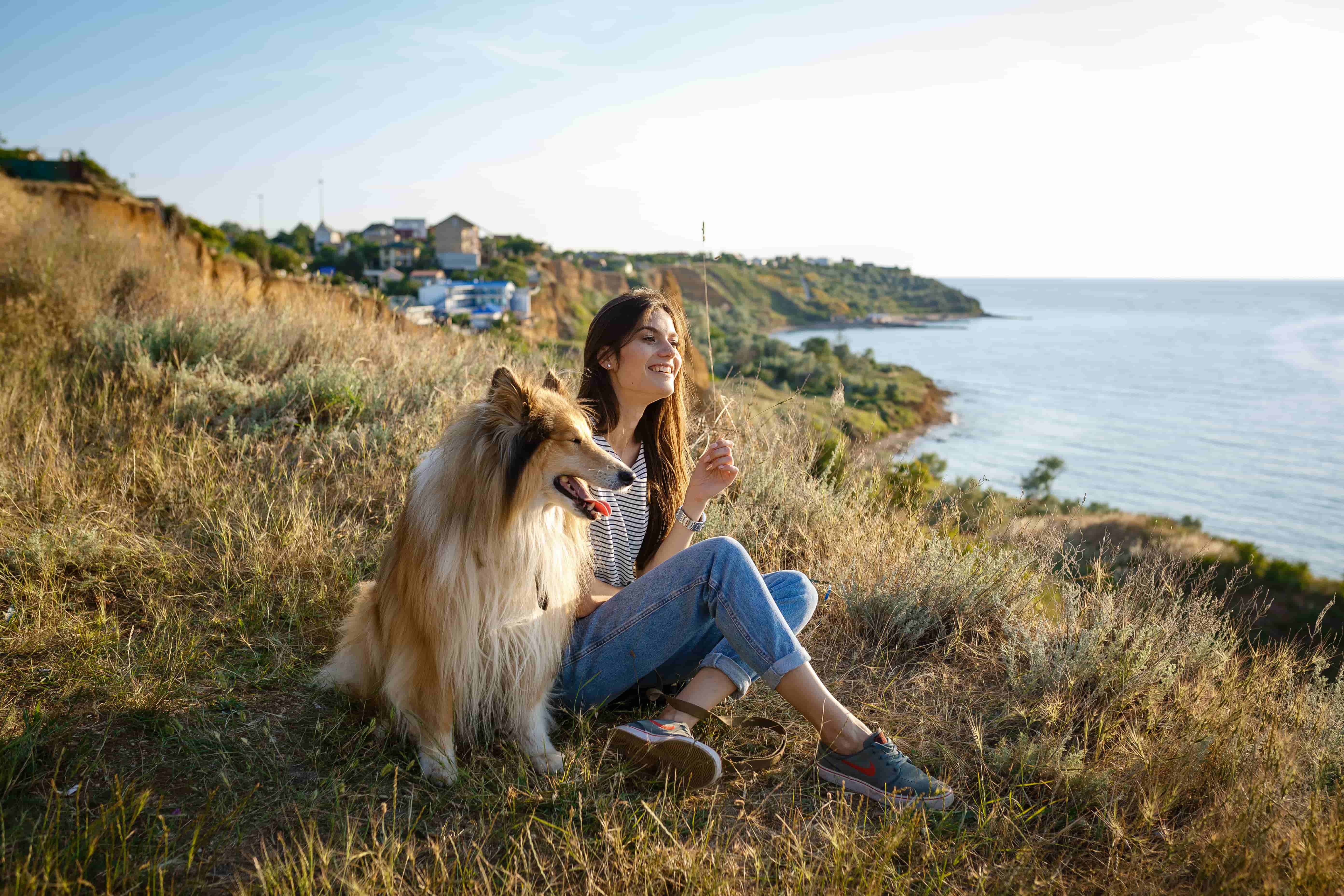 Woman sitting with her dog on the grass
